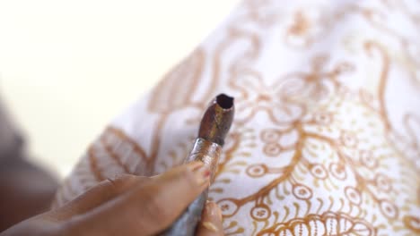the technique of making hand-drawn batik using a canting tool. this craftsman is making batik typical of giriloyo bantul yogyakarta.