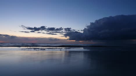 seaside after sunset with a mirror reflection of the sky in the water