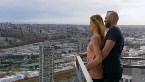 couple pointing at distance in balcony 4k