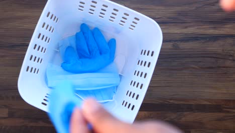 disposing of used gloves and masks in a white basket