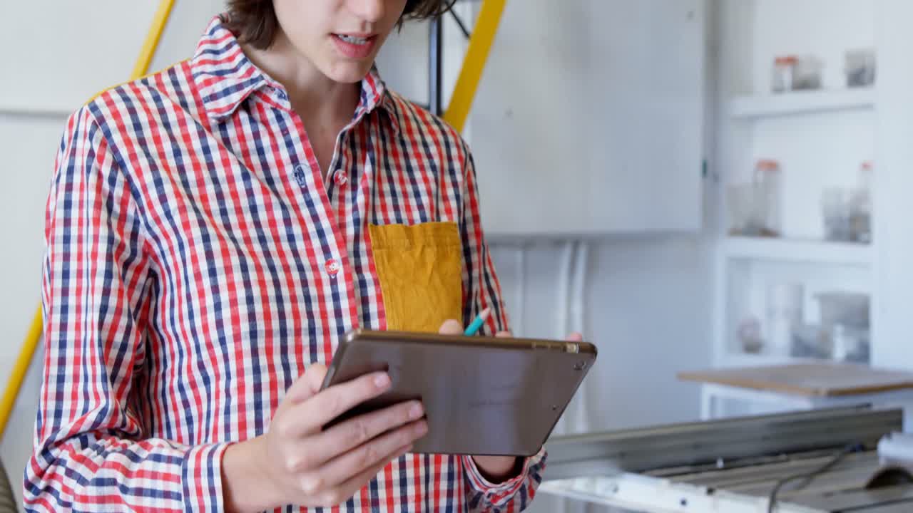 carpintero usando una tableta digital en el taller 4k