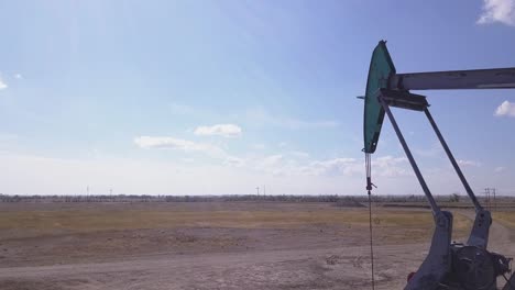 Pumpjack-Bombea-Hacia-Arriba-Y-Hacia-Abajo-En-El-Lado-Derecho-Del-Marco-En-Un-Día-Soleado-De-Pradera