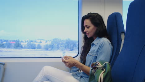 mujer usando un teléfono inteligente en un tren