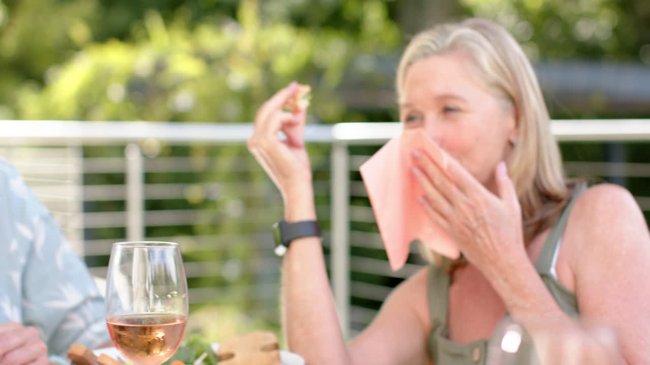 Senior Caucasian women enjoy a meal outdoors