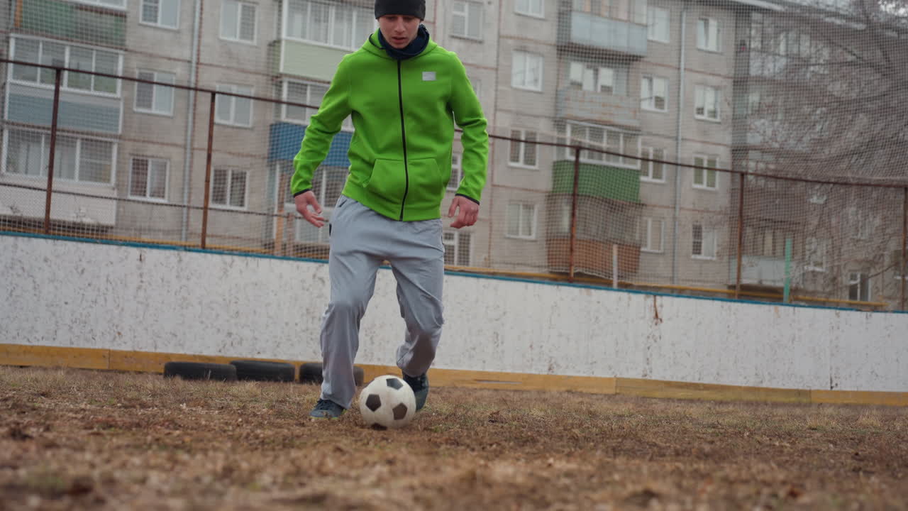 Un atleta domina el juego de pies y el control, un concursante practica el manejo rápido del balón a solas y un individuo demuestra técnicas precisas de manipulación del balón durante una sesión de entrenamiento individual en un campo accidentado.