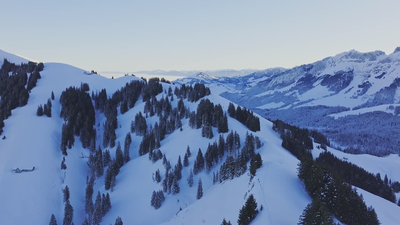 Drone view of the sunrise illuminating the silhouette of a snowy ...