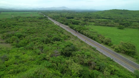 aerial: big 18-wheelers and cars drive along the scenic panamerican highway.