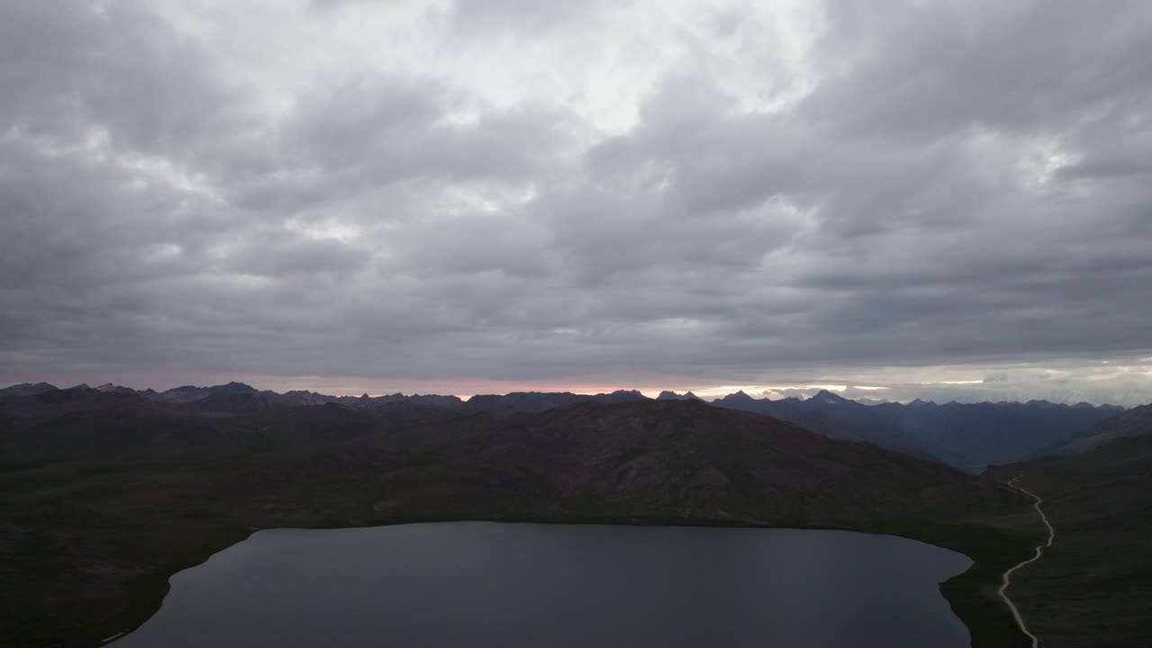 Still waters of Sheosar Lake surrounded by alpine meadows in Deosai National Park. Pakistan