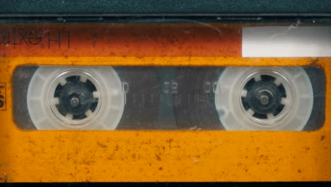 the vintage yellow audio cassette in the tape recorder rotates