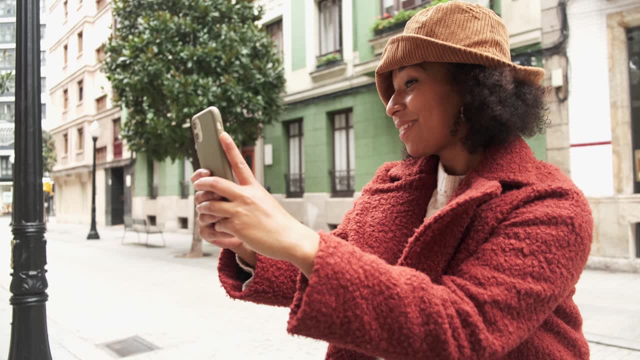 mujer negra sonriente tomando una selfie
