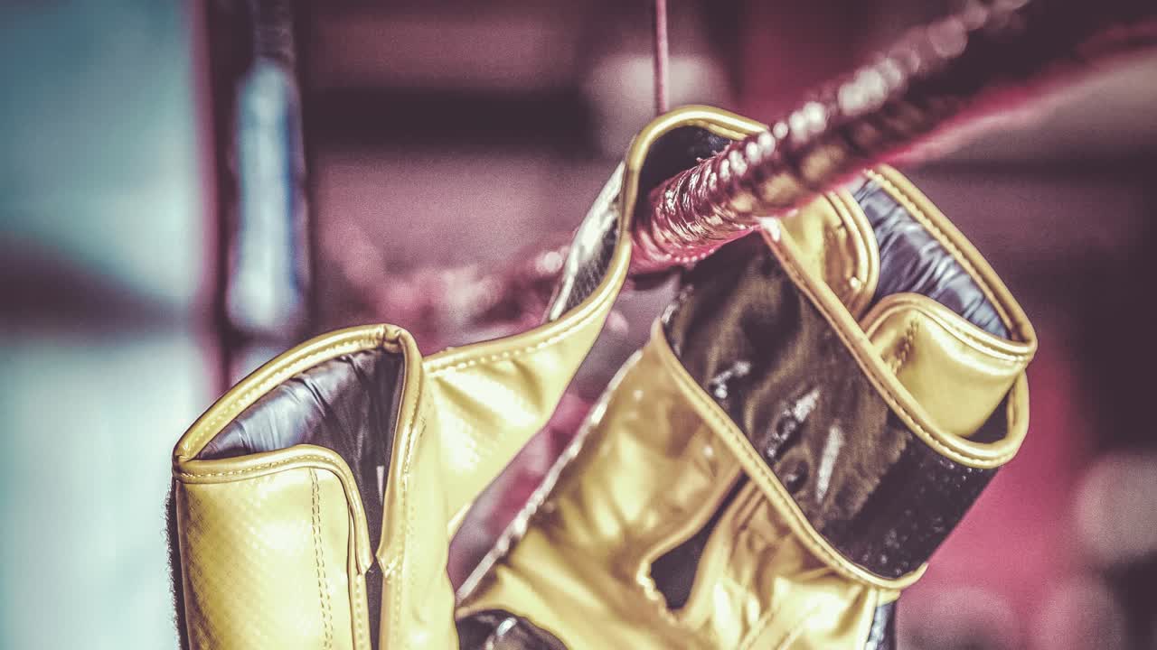 권투 링의  ⁇ 에 매달린 노란색 권투 장갑의 애니메이션