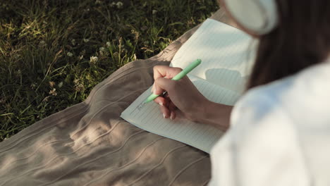 person writing in journal outdoors