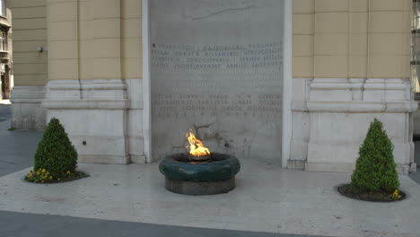 tilt up to the eternal flame war memorial in sarajevo, bosnia and herzegovina. wide front shot in slow motion as fire burns.