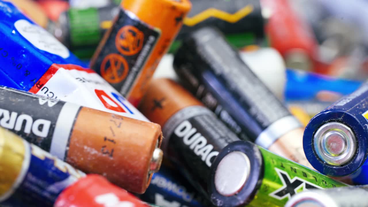 Multiple used Varta AA alkaline batteries are seen arranged in a pile. Hazardous waste concept