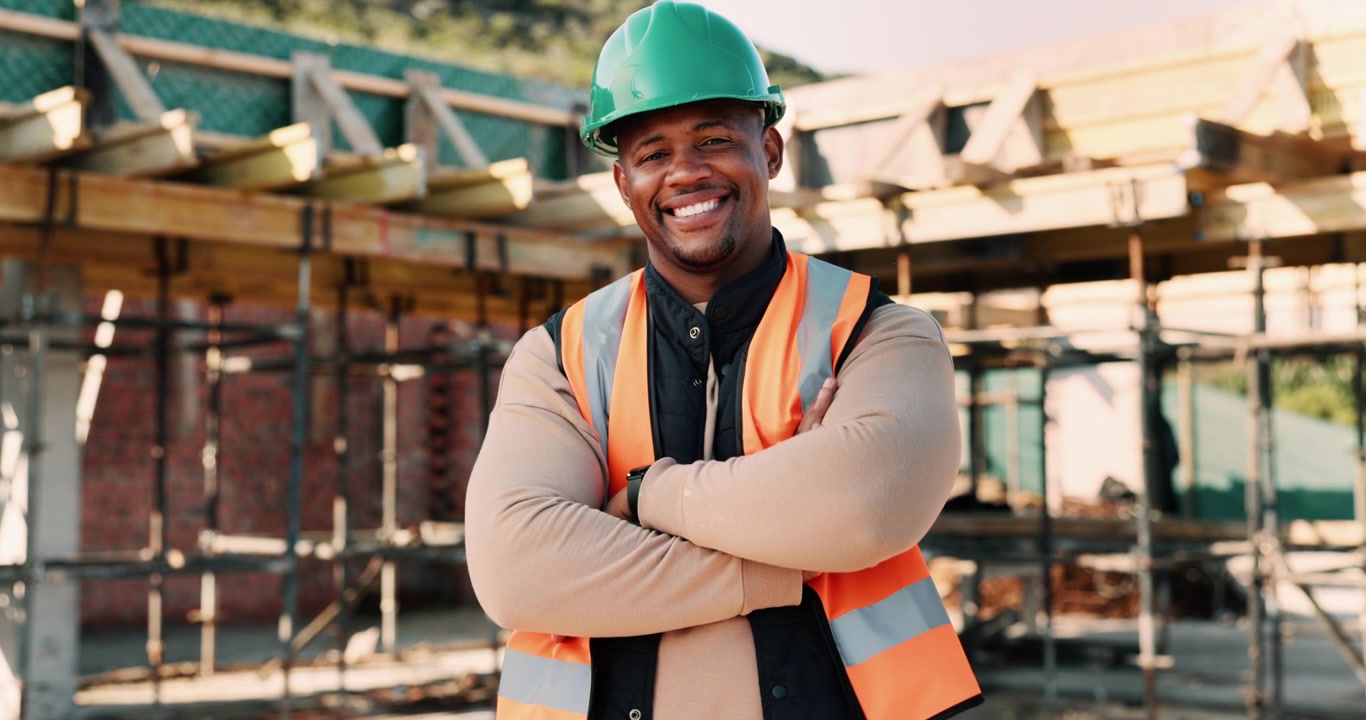 Smiling Construction Worker Wearing Safety Gear at Building Site