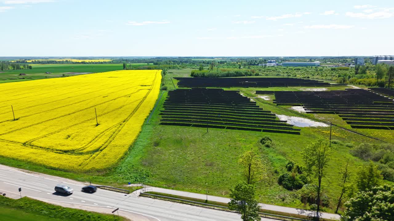 Aerial establishing of solar panels beside blooming rapeseed fields in vibrant agricultural setting