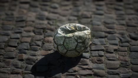 vieja pelota de fútbol en el patio del pavimento