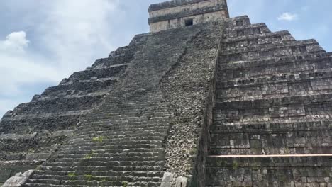 handheld close-up tilting up shot of the ruins of the steep steps on the backside of kukulkan's pyramid in chichen itza, mexico. 4k