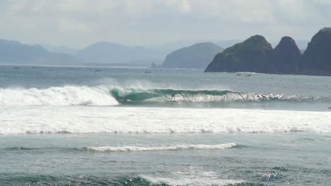 surfer surfing past a small island