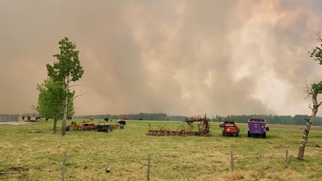 thick smoke from wildfires fills the sky above agricultural fields