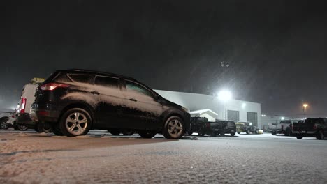 nieve cayendo sobre los coches estacionados en el estacionamiento