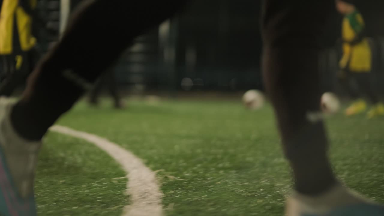 Tim sepak bola anak-anak berlatih di stadion di bawah bimbingan seorang pelatih. Anak-anak berseragam olahraga berlatih latihan bola, meningkatkan teknik, dan mengembangkan kerja sama tim di lapangan hijau