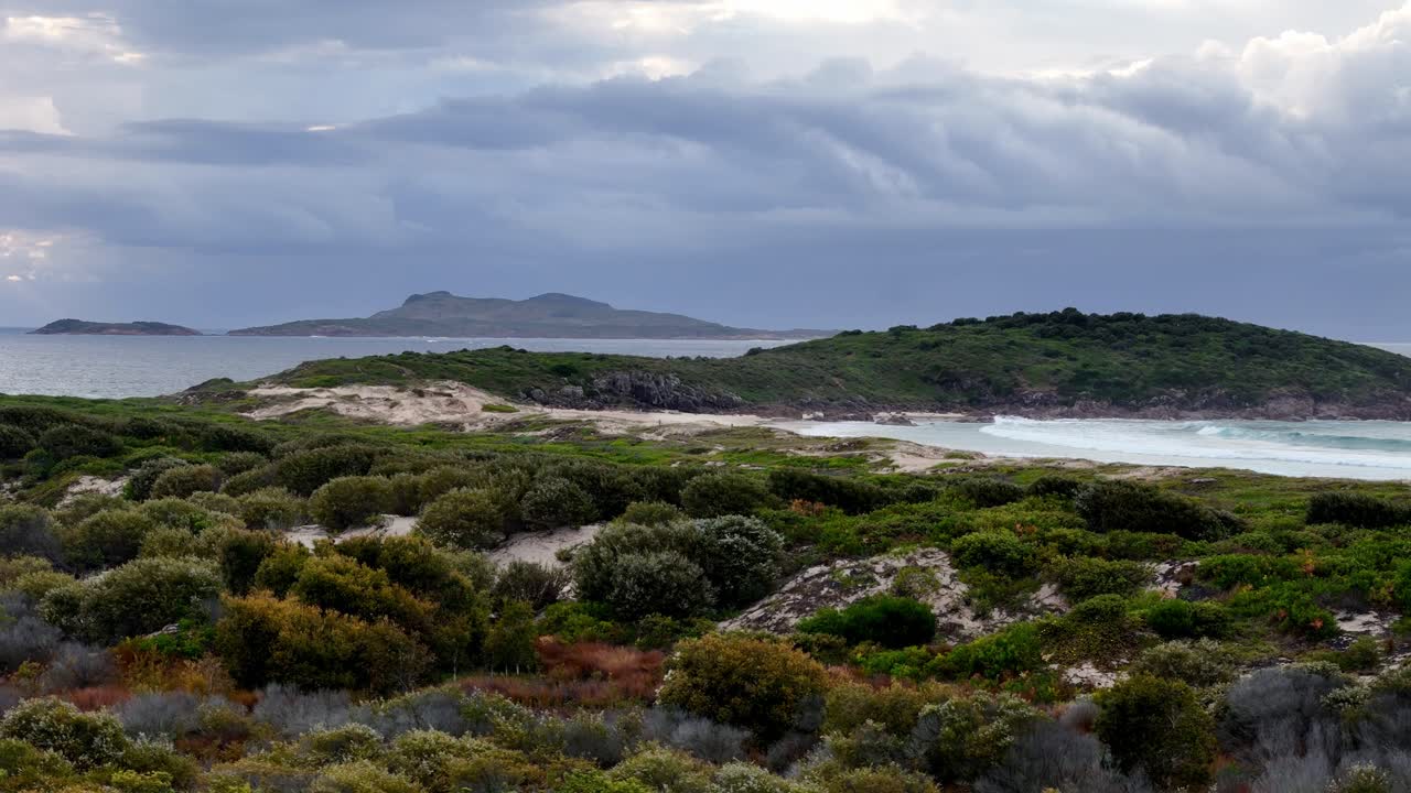 небольшой остров с травянистым холмом на его стороне и водоёмом на заднем плане