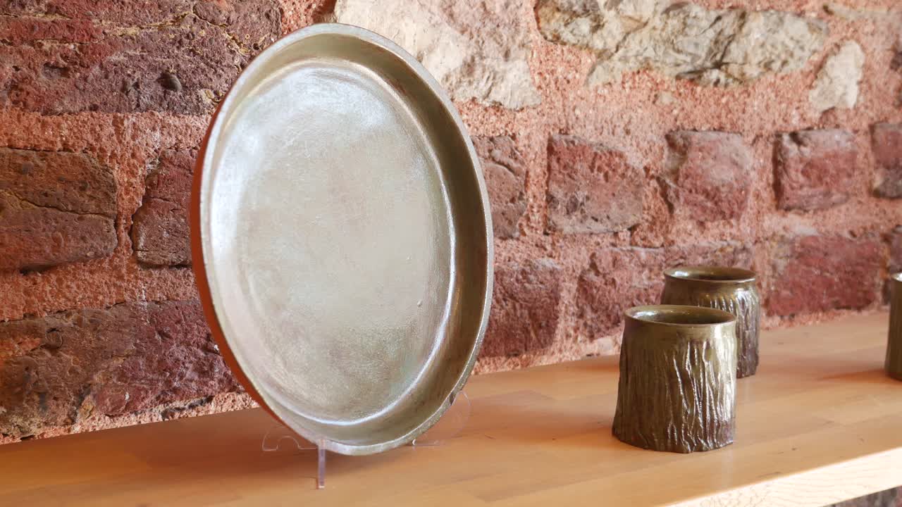 platos y tazas de cerámica hechos a mano en un estante