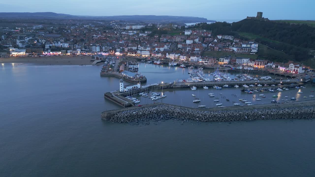 tomada de drones de gran ángulo del puerto de scarborough durante la puesta de sol con un hermoso paisaje urbano en el fondo en inglaterra