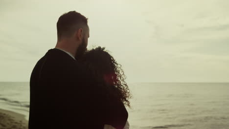 Lovers-looking-sea-view-on-beach-date.-Couple-hugging-standing-at-water-nature.