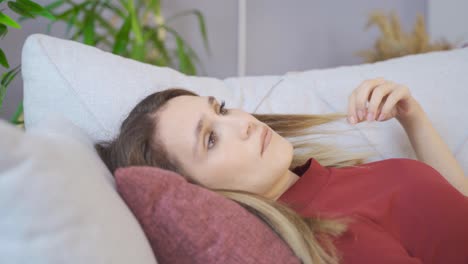 Una-Mujer-Pensativa-Se-Acuesta-En-El-Sofá-Y-Juega-Con-Su-Cabello.