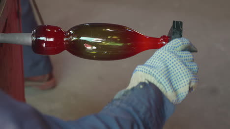 a close up of a man shaping hot glass