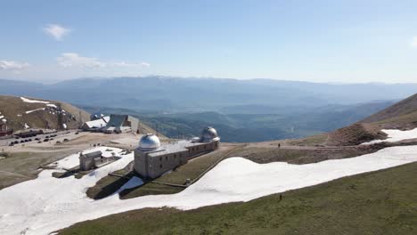 Wide-angle-drone-shot-overlooking-an-observatory-located-on-top-of-a-mountain-in-a-busy-ski-location-in-the-region-of-Abruzzo-in-Italy