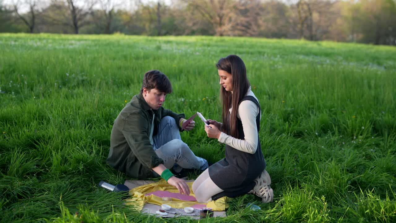 Couple Playing Cards in a Park