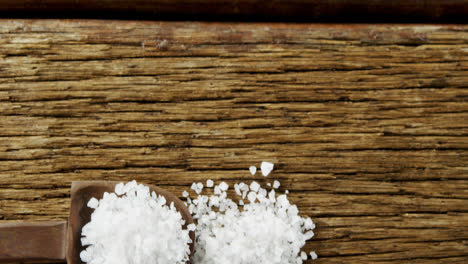 salt in spoon on wooden table 4k