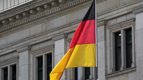 4k. flag of germany waving in the wind in front of a historical building