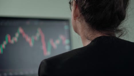 mature woman brunette looks on monitor searching currency trend