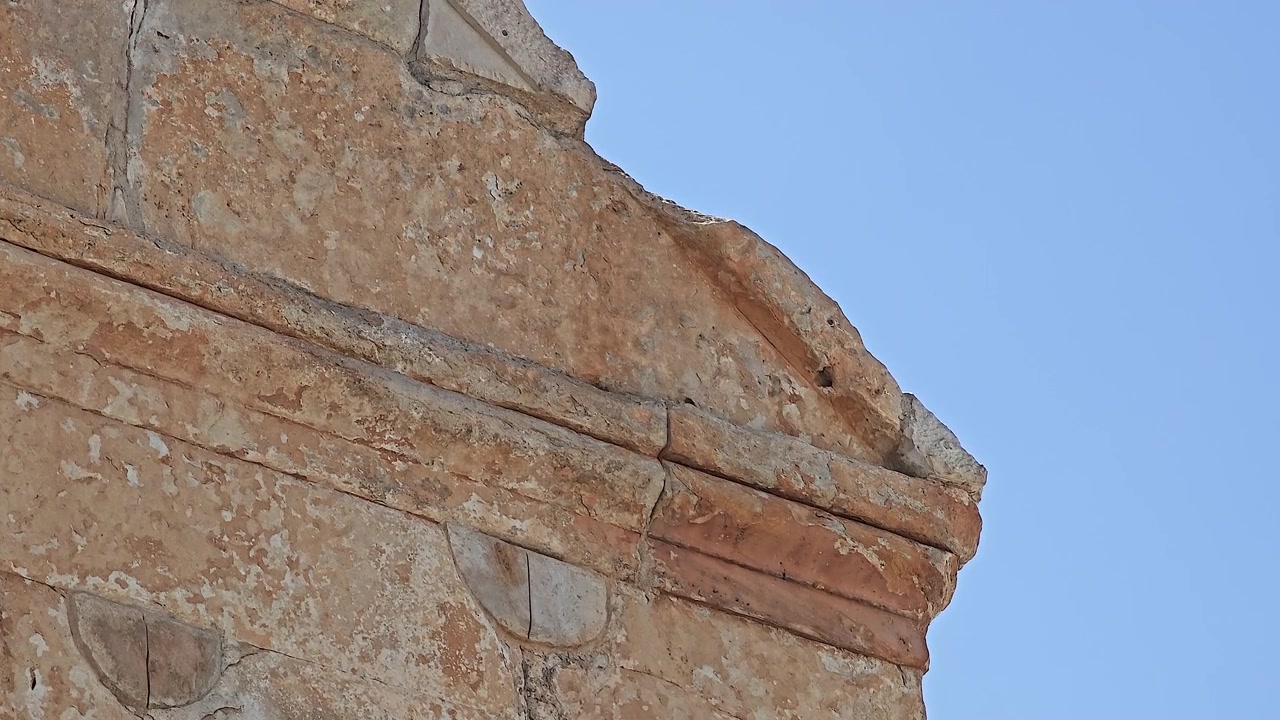 Close-up de uma Fachada de Edifício de Pedra Antiga Contra um Céu Azul Claro.