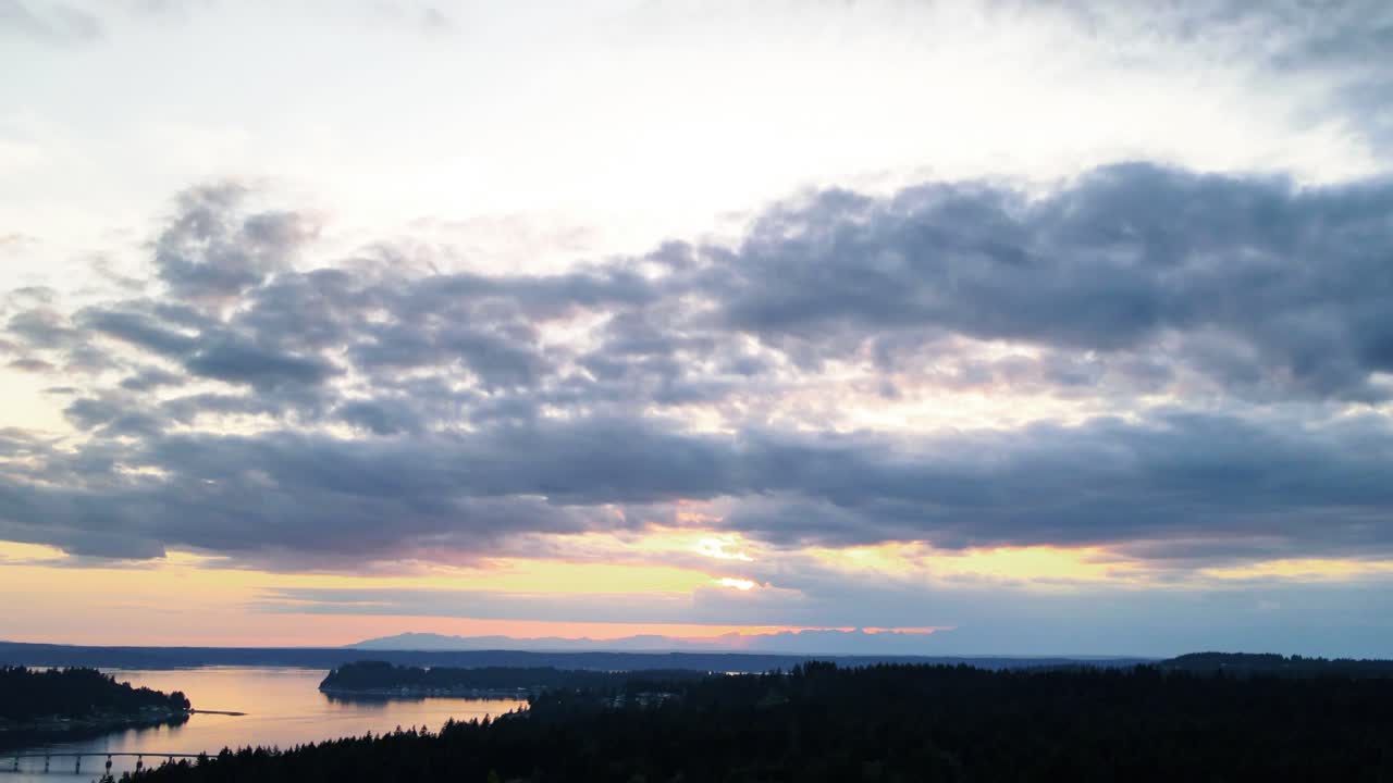nubes ominosas oscuras se extienden a través de un cielo de puesta de sol de ámbar dorado profundo, hiperlapso aéreo