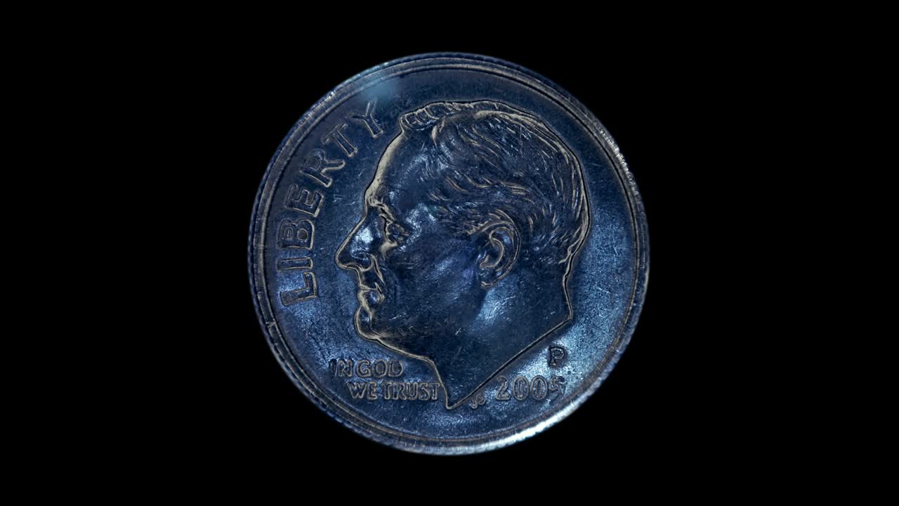 sobre un fondo negro, una moneda de diez centavos brilla en los rayos de luz