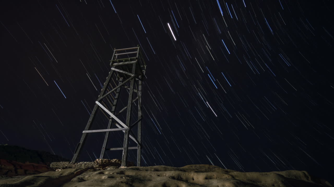 rastro de estrellas en la playa local con un viejo reloj de tiburones