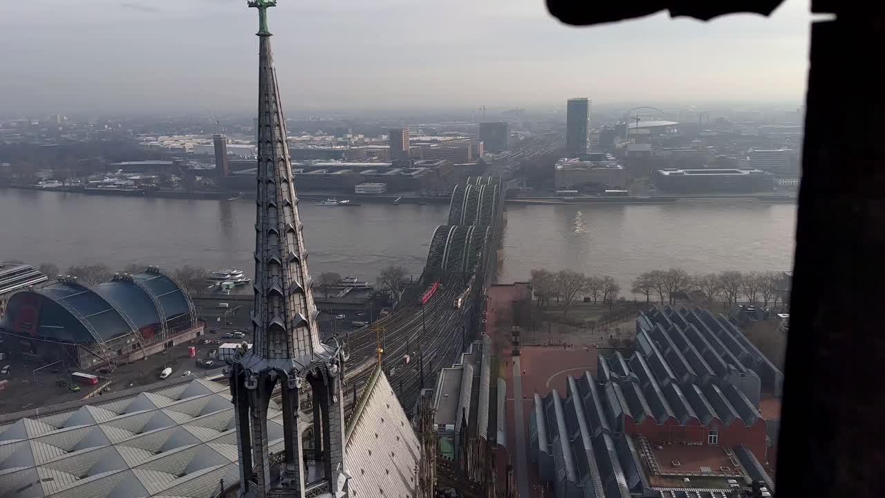 안개가 자욱한 날 라인강을 건너는 기차와 함께 호헨졸렌 다리에 있는 쾰른 대성당에서 공중 하향식 샷