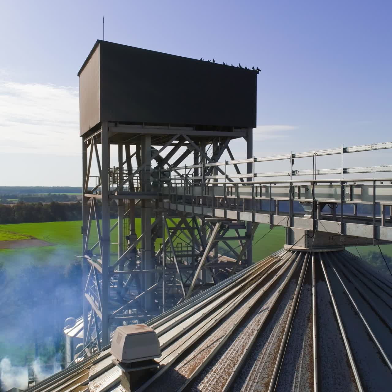 Aerial view of metal grain elevator in agricultural zone. Grain warehouse