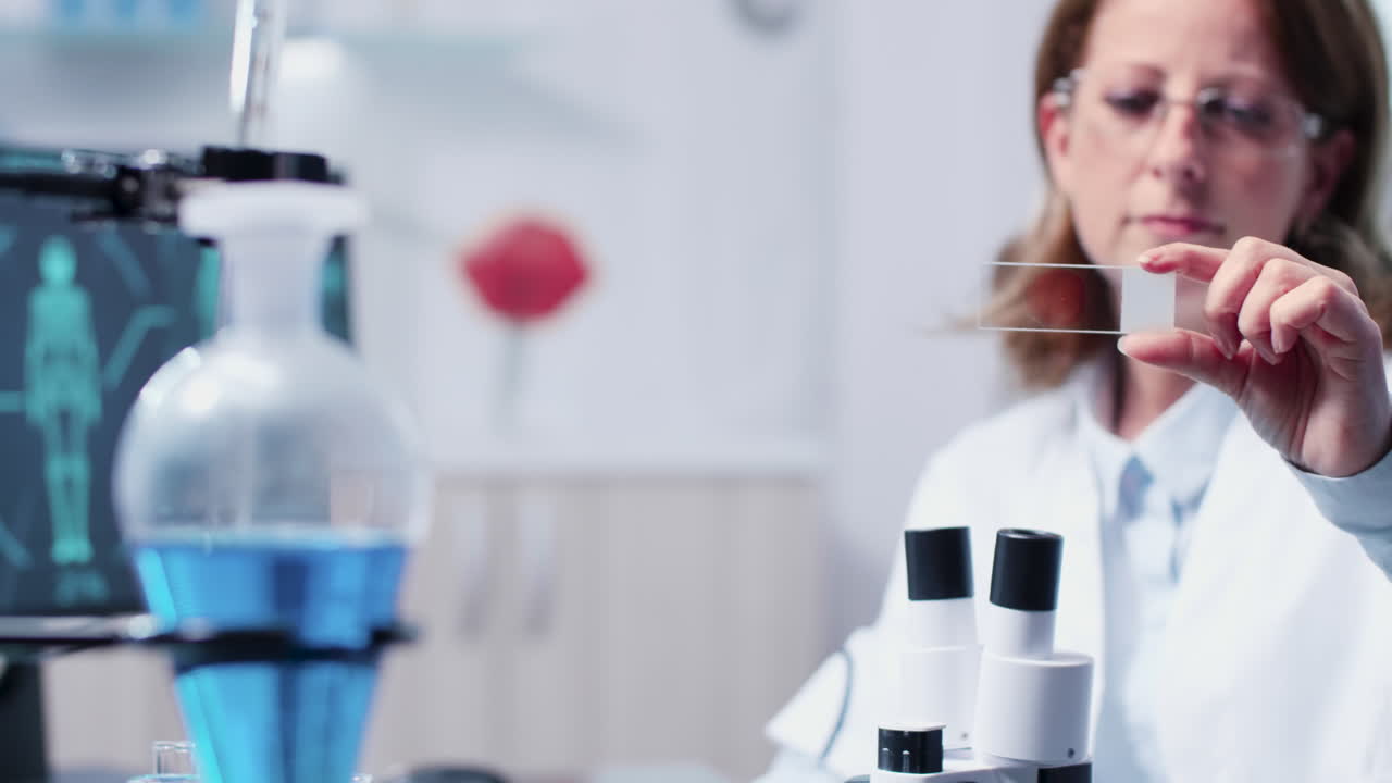 Scientist analyzing a sample under a microscope in a lab