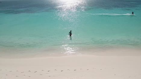 Drone-shot-Man-giving-kitesurf-lessons-inside-caribbean-beach-at-sunset