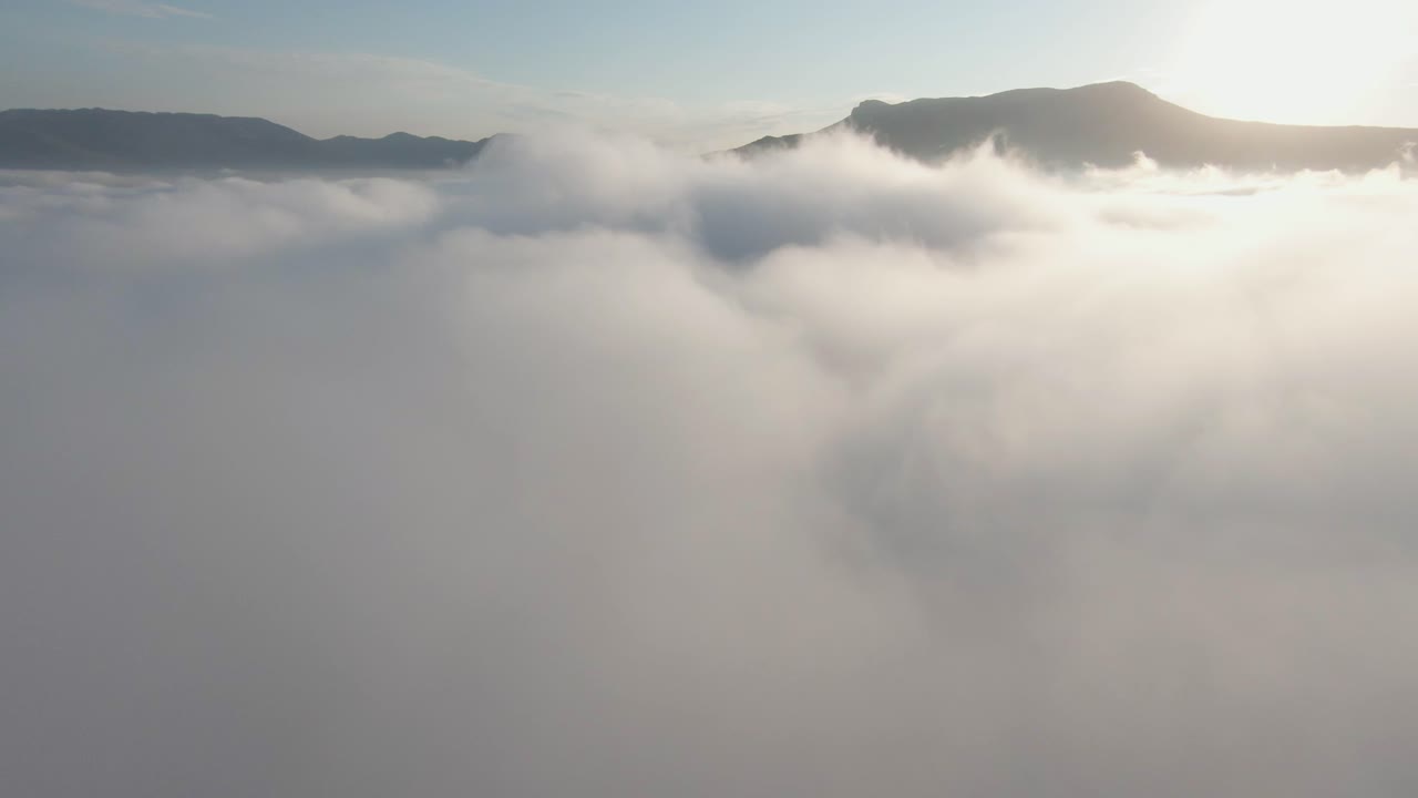 산 위의 구름을 통해 해가 뜨는 것