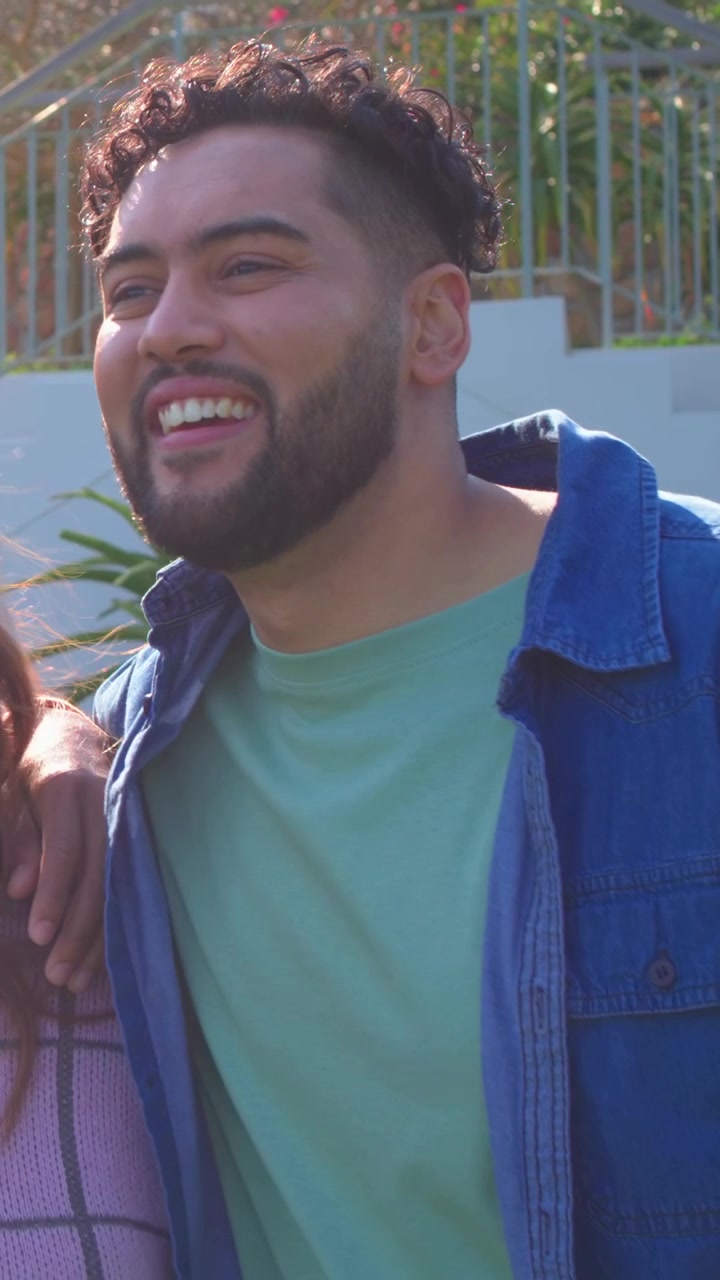 Uomo che cinge la donna con un braccio, la telecamera panoramica rivela il profilo dell'uomo che si gira vicino a una parete bianca per annunci pubblicitari.