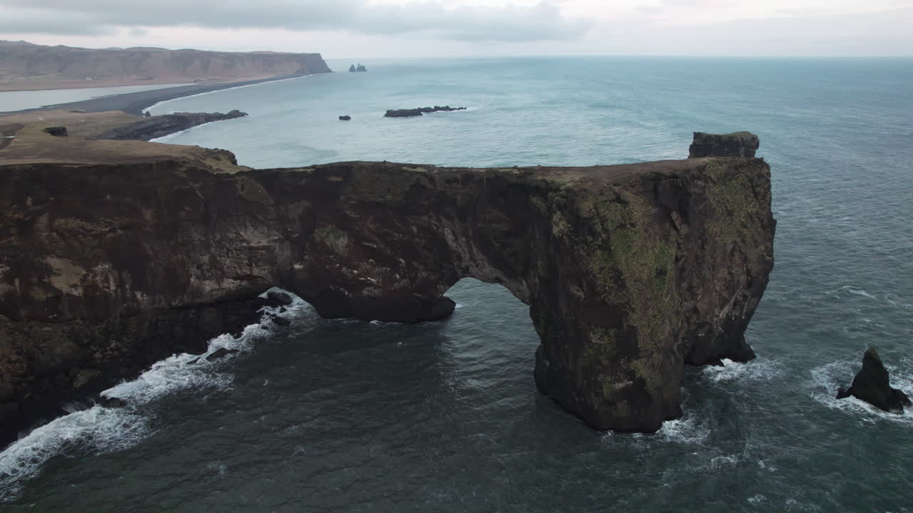 plataforma rodante aérea hacia atrás lejos del arco dyrholaey en el sur de islandia