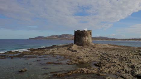 Close-up-aerial-view-of-the-tower-located-on-Isola-della-Pelosa,-Sardinia-on-a-sunny-day