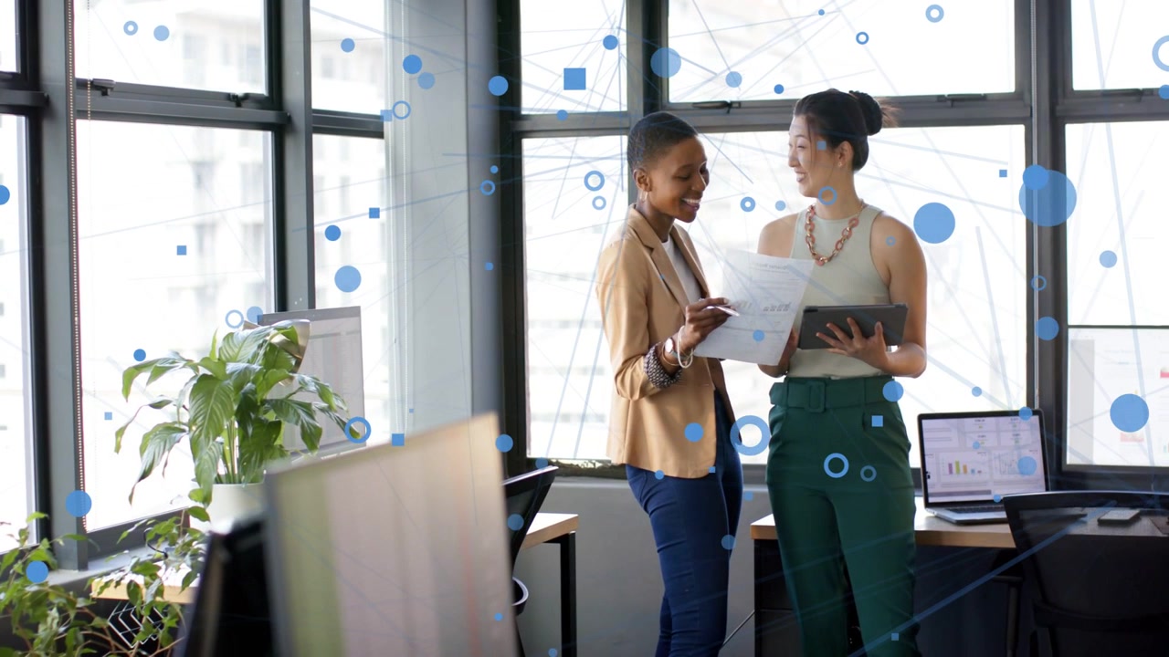 Two coworkers tapping paper, scrolling tablet, aligning business chart, blue overlay tracing data